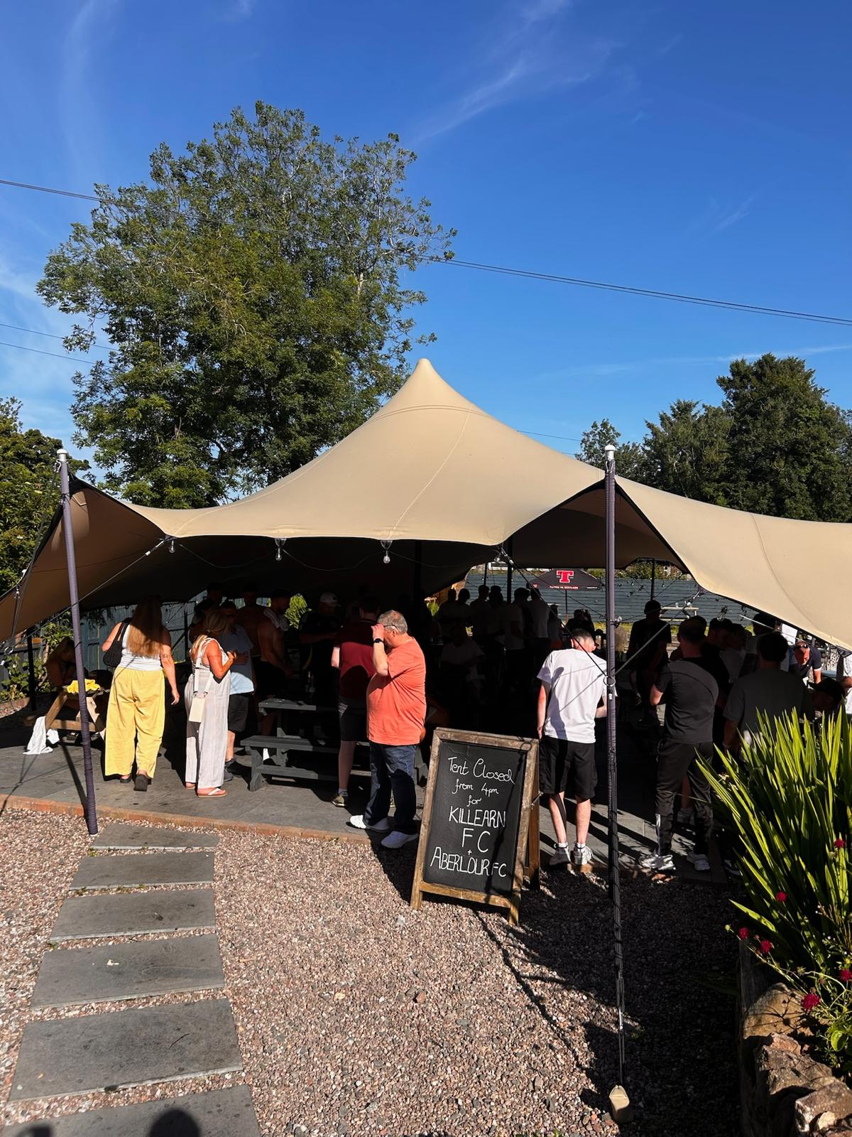 Guests gathered under the marquee for a party in the garden patio